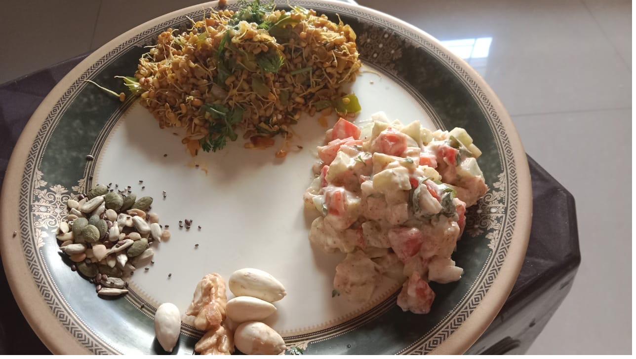 A textbook ProteinPlate: a protein (sprouts), a curd-vegetable salad, and a corner of nuts and seeds.