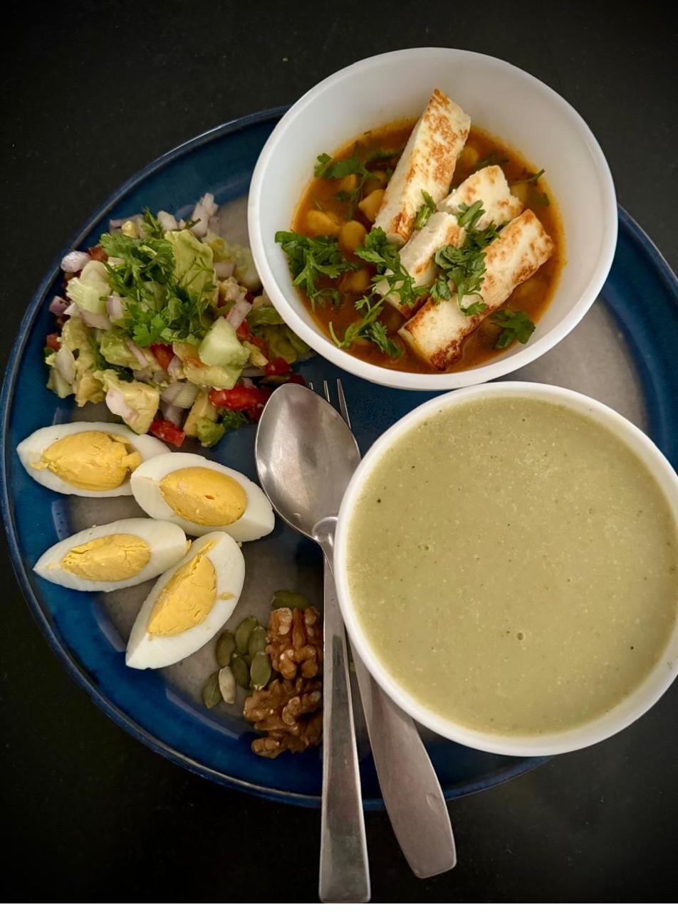 Annotated rich plate: eggs, chana with paneer, green soup, avocado salad, nuts and seeds.